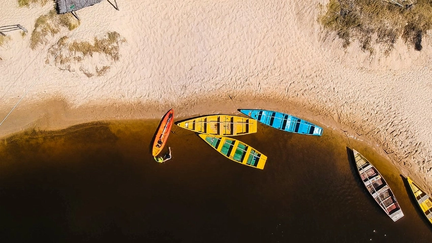 Aerial shot of vibrant boats on a sandy beach in Baía Formosa, Brazil