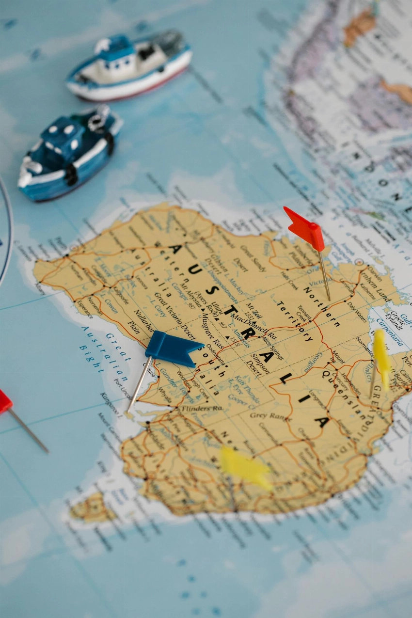 Toy boats and flags highlight locations on an Australia map, featuring a nautical theme