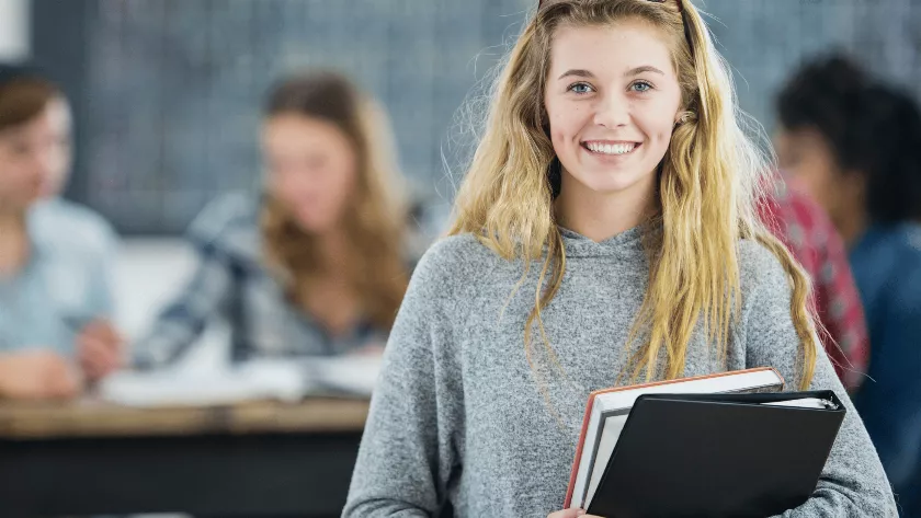 A girl student with books in her arms