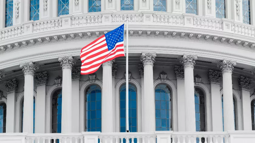 US flag with a building in the background