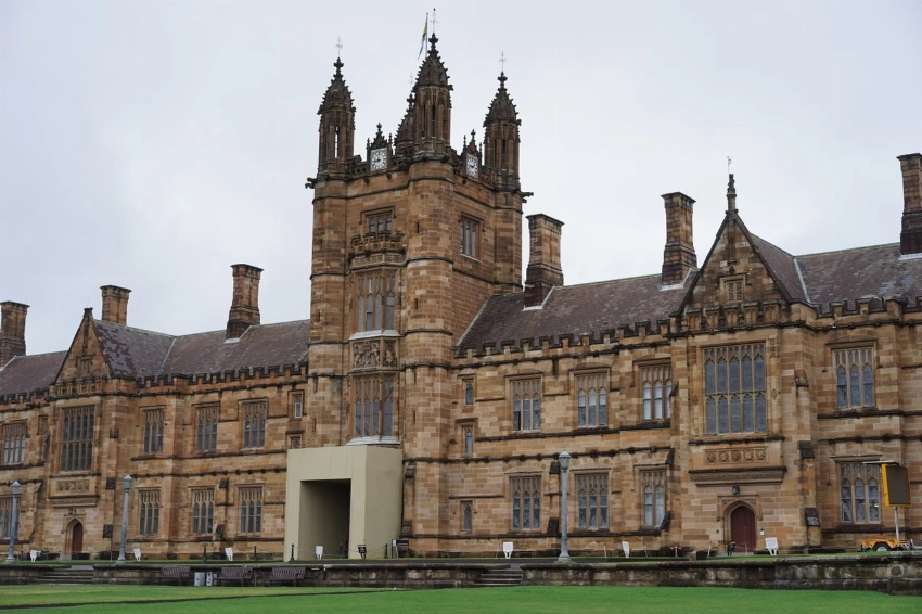 Gothic architecture of a historic university quadrangle building captured on a cloudy day