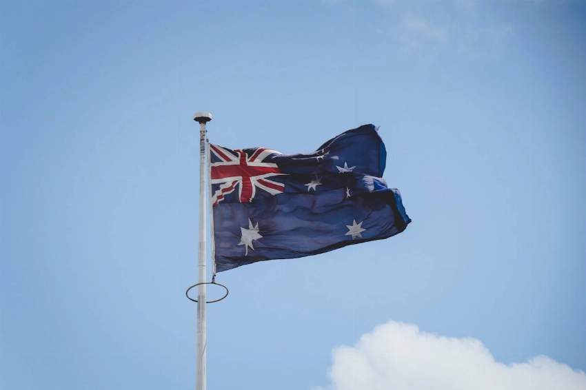 Australian national flag waving on a flagpole against a clear blue sky in Perth