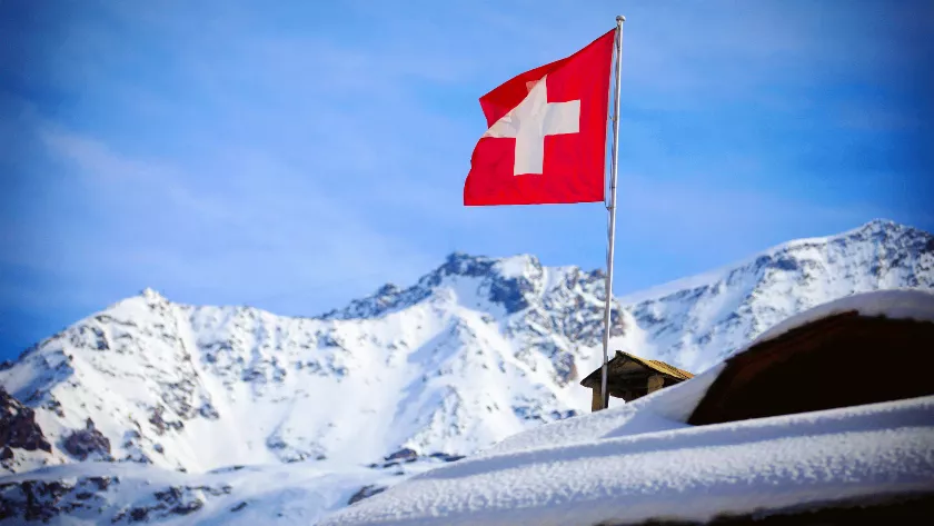 Swiss flag with mountains in the backdrop