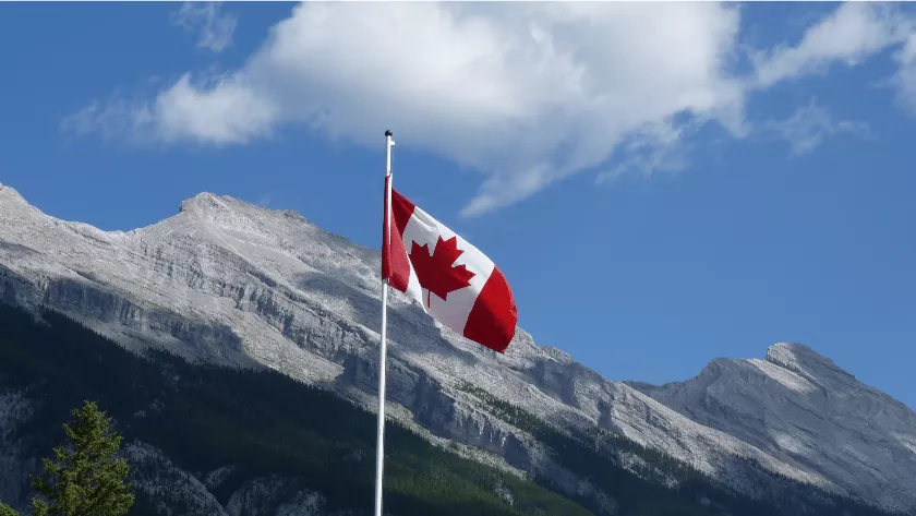 Canadian flag infront of some mountains