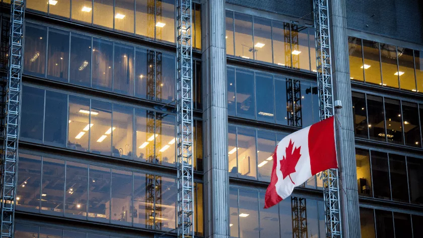 Canada flag infront of a glass building